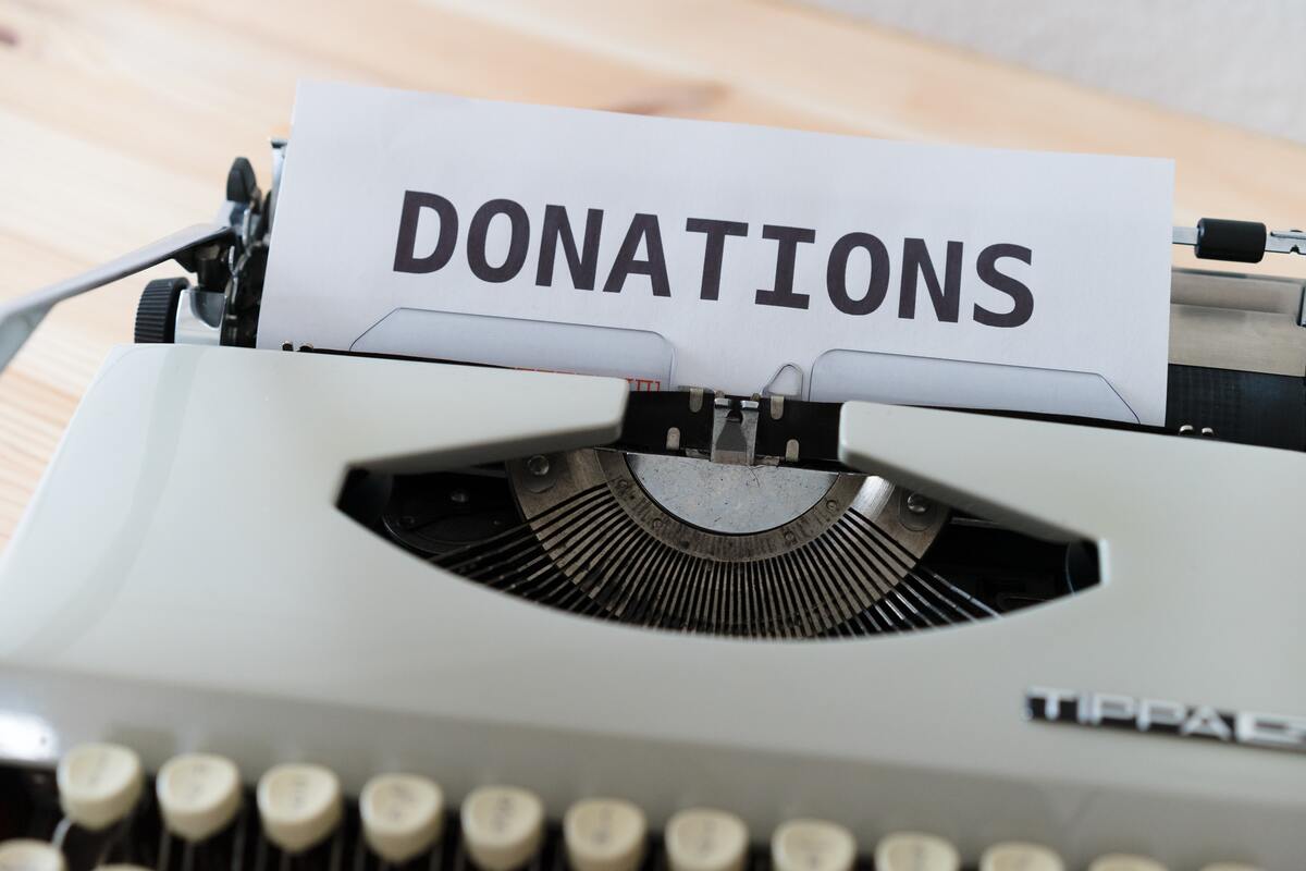 A old school typewriter with paper in it. On the paper is printed donations